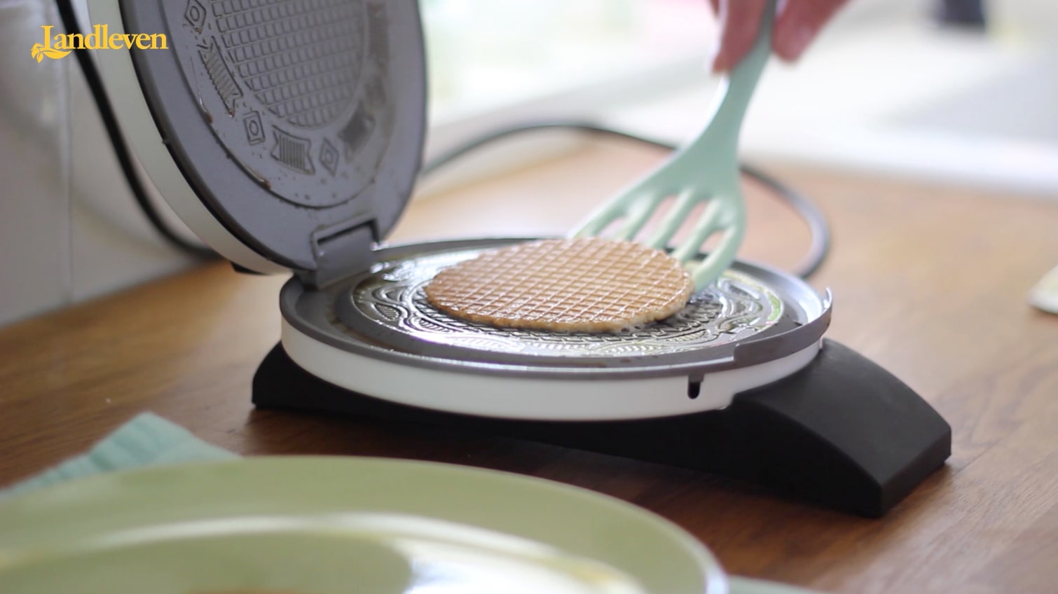 Stroopwafel uit een wafelijzer scheppen.